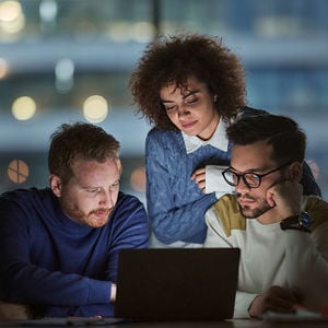 Coworkers Sharing Laptop Screen 