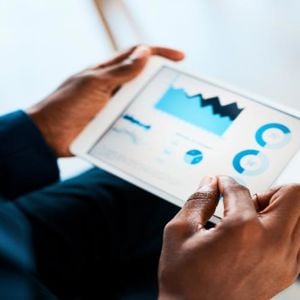 Hands Holding Tablet With Charts 