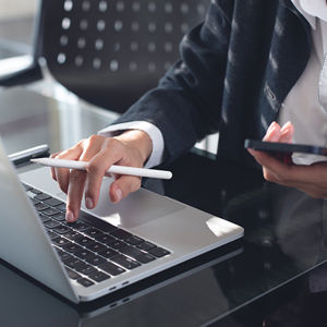 Person Using Laptop And Phone 