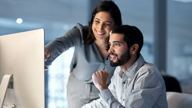 Coworkers Reviewing Work On Desktop 