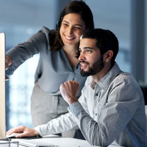 Coworkers Reviewing Work On Desktop 