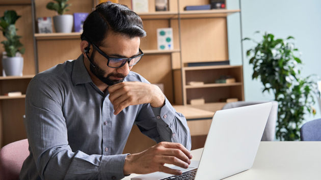 Office Working Concentrating On Laptop Screen 