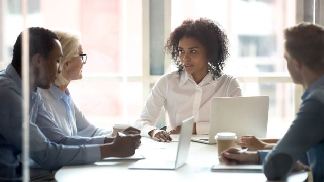 Colleagues Conversing Around Conference Table 