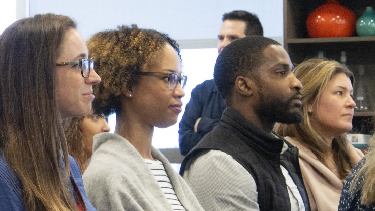 Row of 4 people listening to a presentation at Verisk